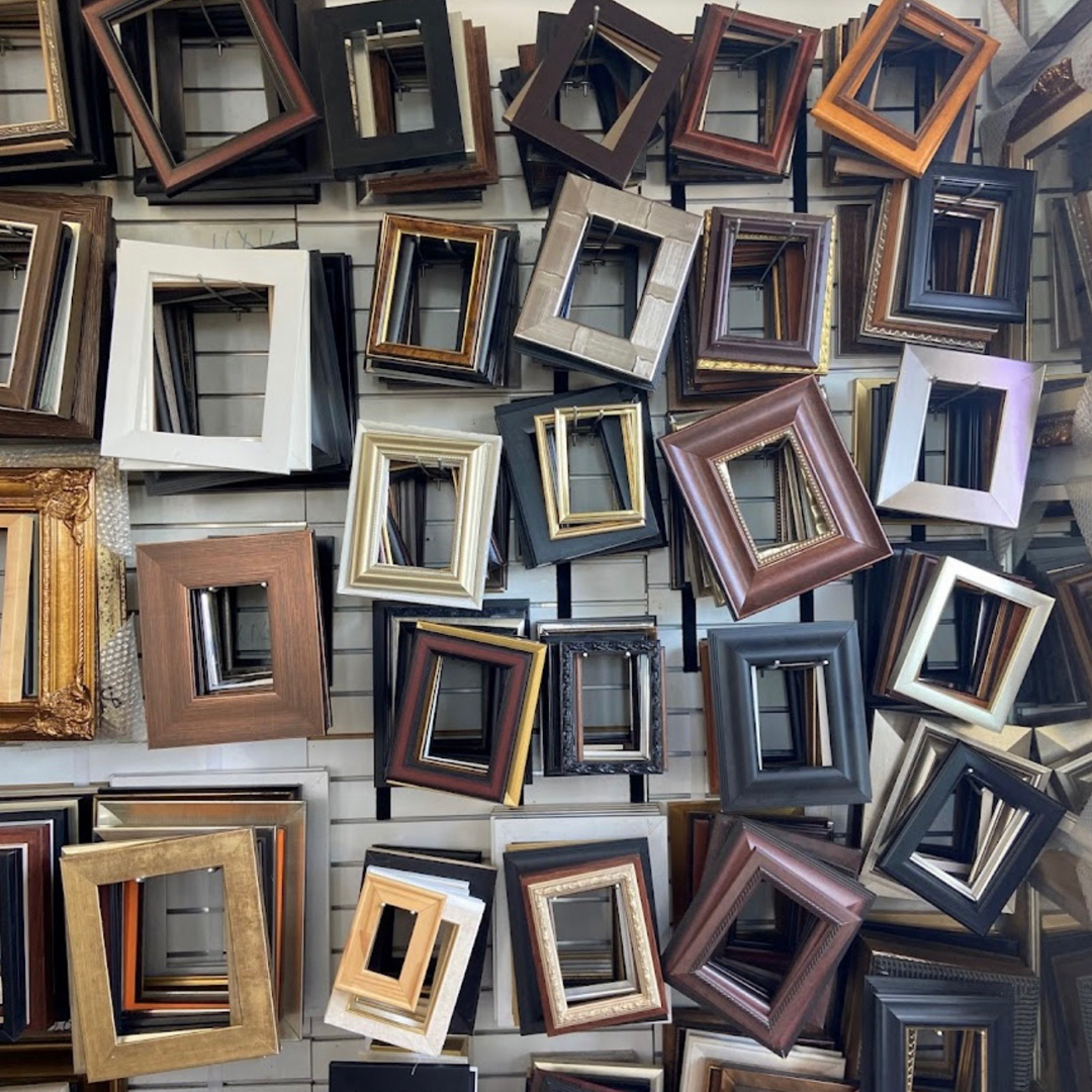 Flat-lay display of dozens of custom picture frames in every style at Picture Framing Warehouse